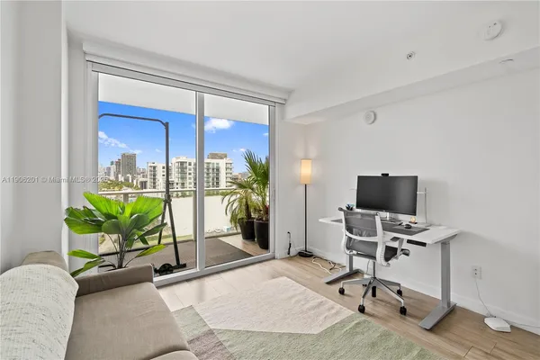 a view of a workspace with furniture and a window