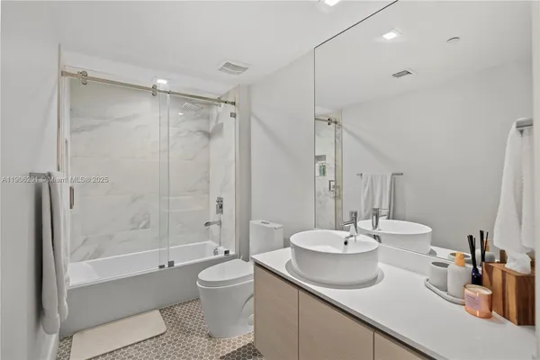 a bathroom with a double vanity sink toilet and shower