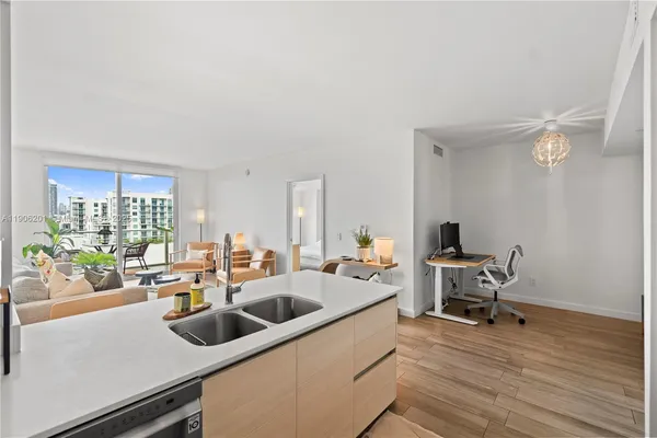 a kitchen with a sink cabinets and wooden floor
