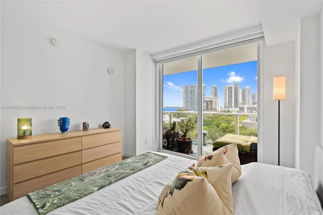 a bedroom with a bed and a large window