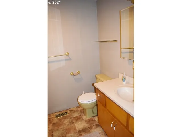 a bathroom with a sink a toilet and a mirror