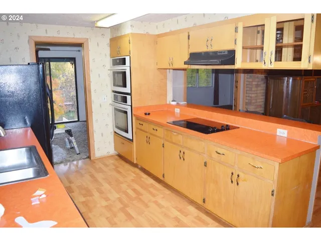 a kitchen with stainless steel appliances kitchen island granite countertop a refrigerator and a stove