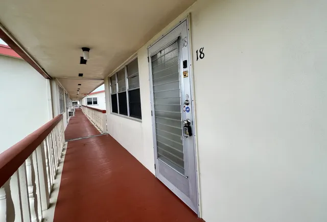 a view of a patio with table and chairs potted plants and a palm tree