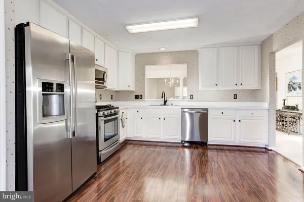 a kitchen with stainless steel appliances a refrigerator sink and cabinets
