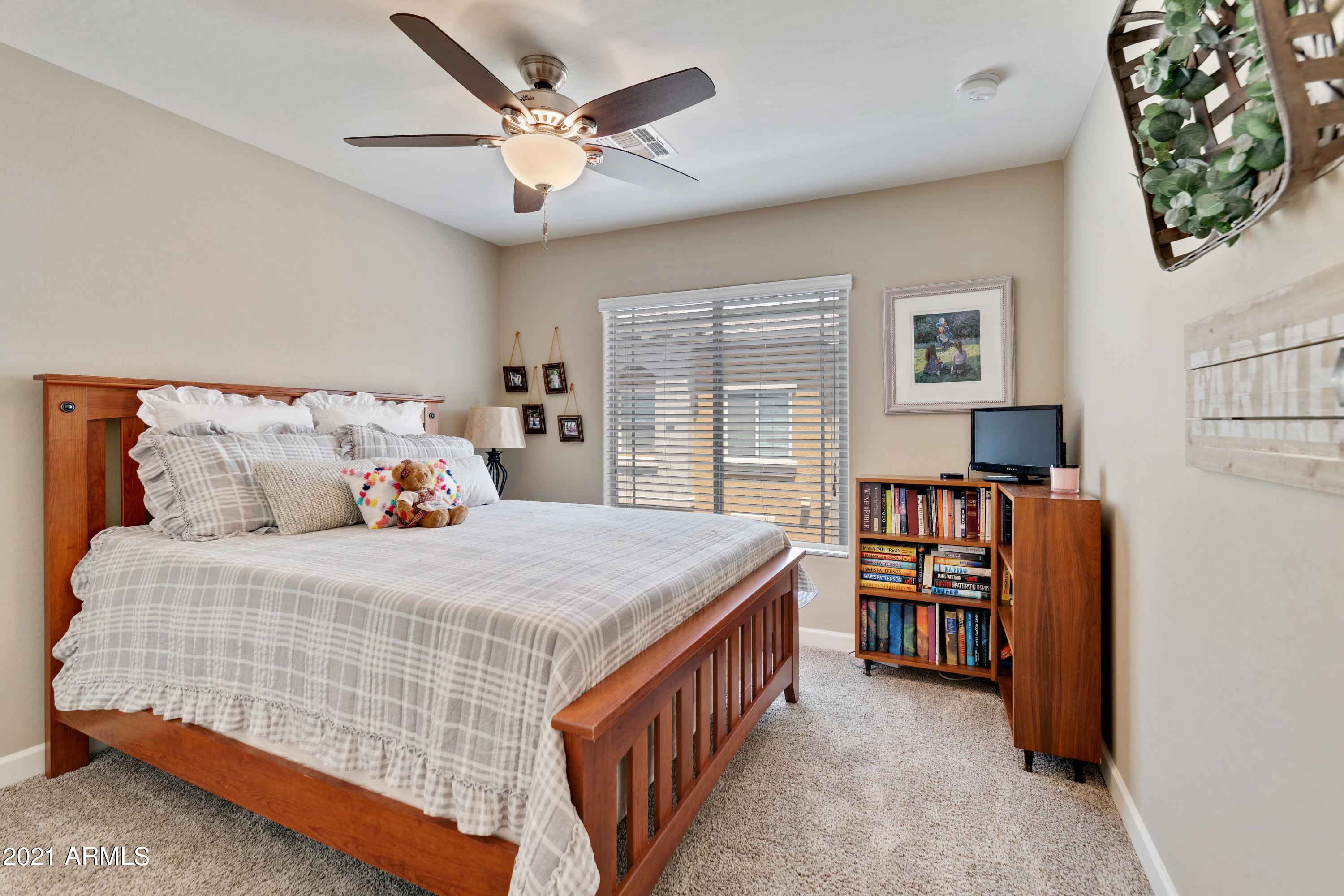 2150 West Alameda Road, Unit 1093 Phoenix, AZ 85085 - Photo 22 of 35 a bedroom with a bed a book shelf and a window