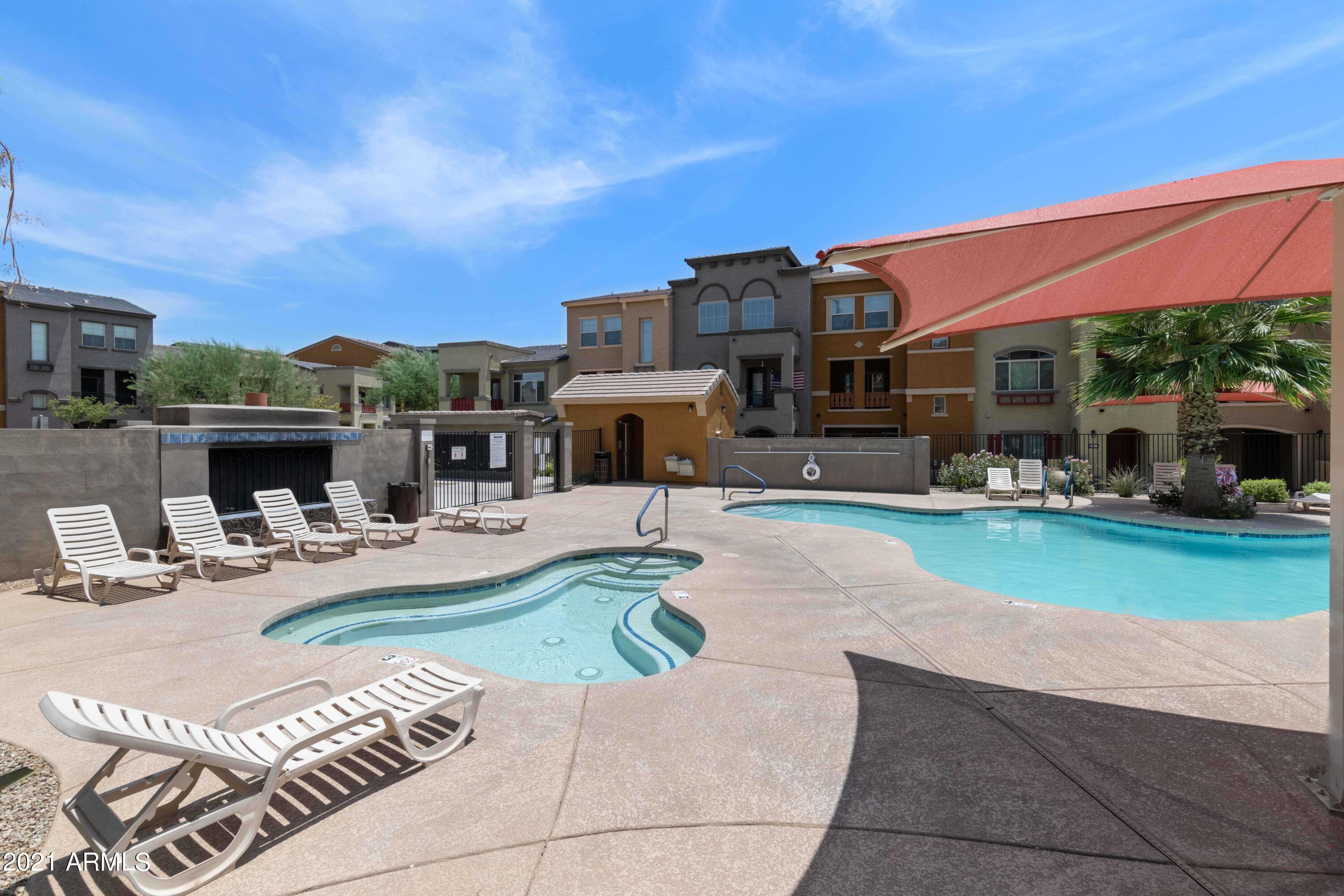 2150 West Alameda Road, Unit 1093 Phoenix, AZ 85085 - Photo 32 of 35 a view of a patio with couches and table and chairs under an umbrella