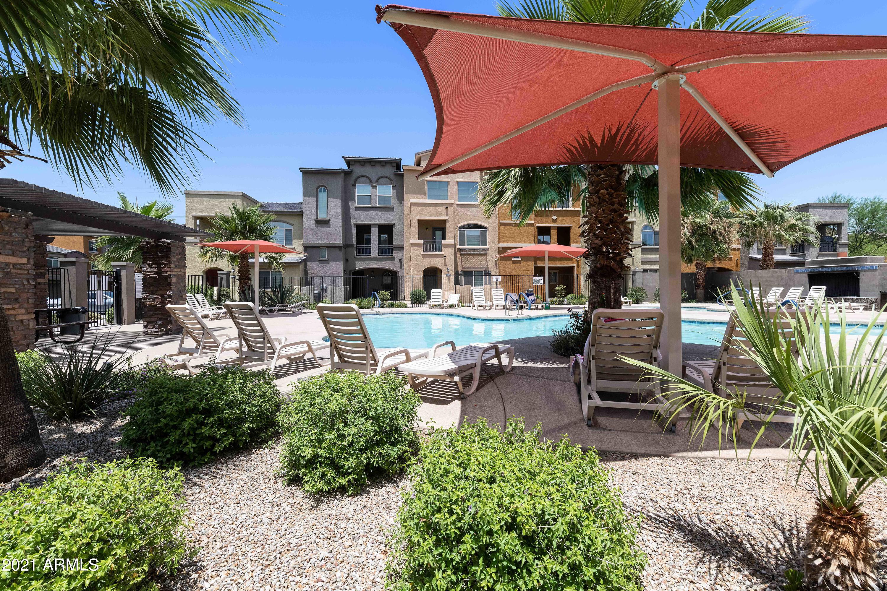2150 West Alameda Road, Unit 1093 Phoenix, AZ 85085 - Photo 34 of 35 a patio with a table and chairs under an umbrella