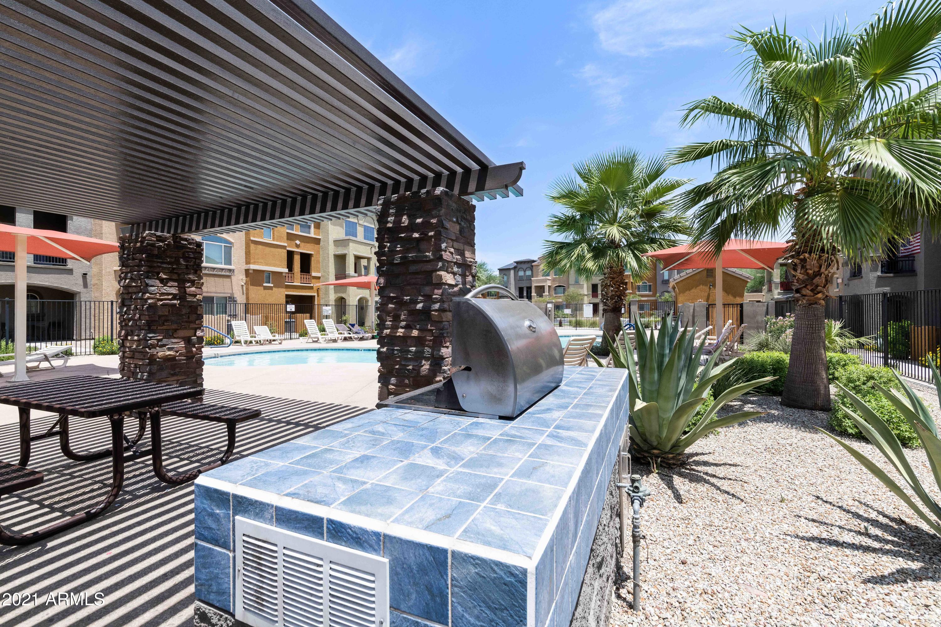 2150 West Alameda Road, Unit 1093 Phoenix, AZ 85085 - Photo 35 of 35 a view of a patio with table and chairs potted plants and palm tree