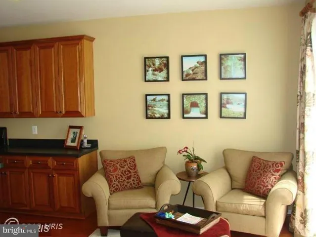 a living room with furniture a wall painting and a window