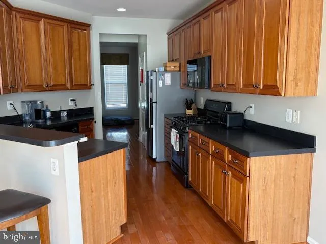 a kitchen with stainless steel appliances granite countertop a sink a stove and a refrigerator