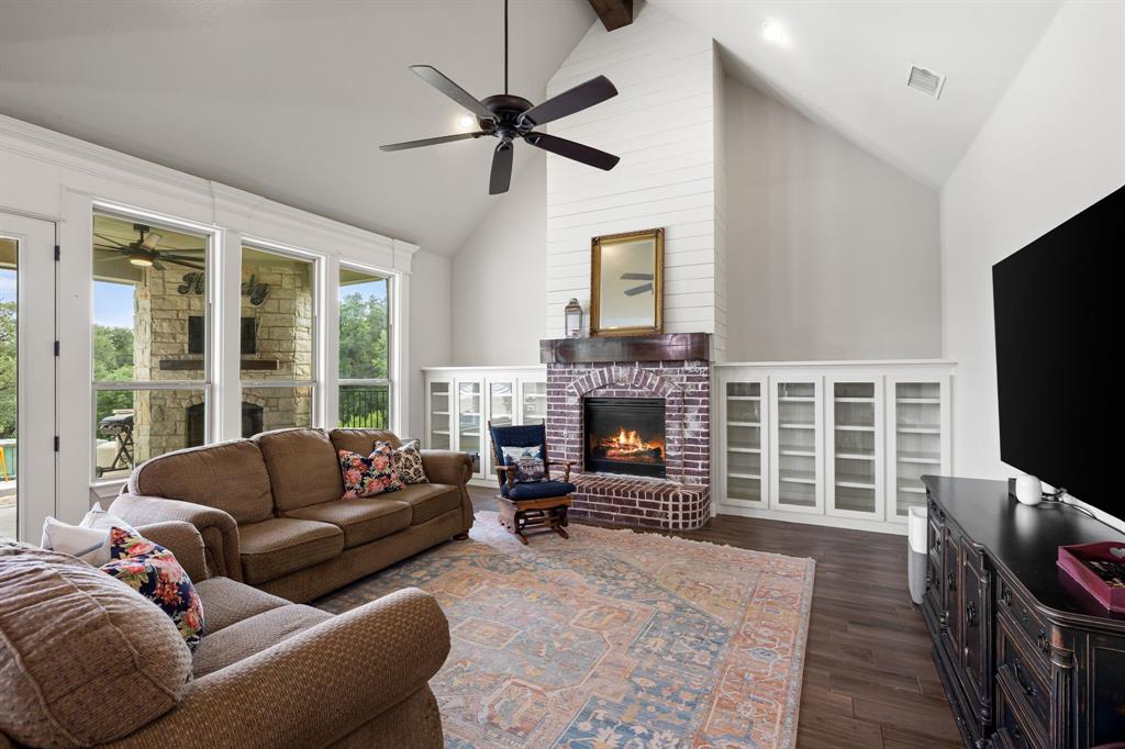 2103 Cash Point Court Granbury, TX 76049 - Photo 8 of 38 a living room with furniture a flat screen tv and a fireplace
