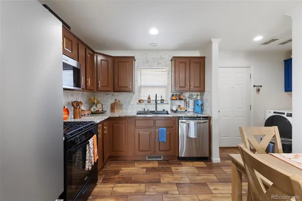 a kitchen with stainless steel appliances granite countertop a sink stove and cabinets