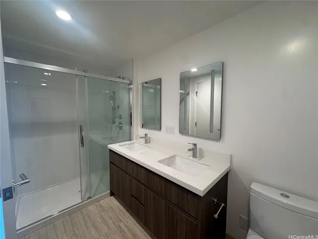 a bathroom with a sink toilet a mirror and shower