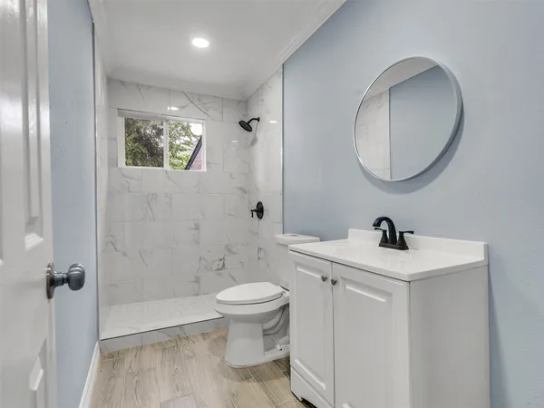 a bathroom with a toilet a sink and mirror