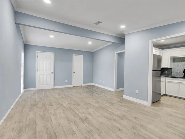 a view of empty room with kitchen and window