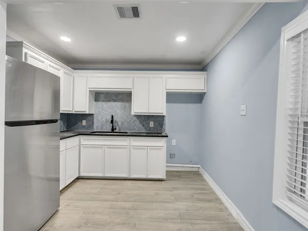 a kitchen with a sink a refrigerator and window