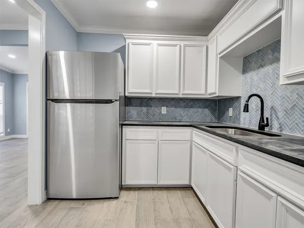 a kitchen with a refrigerator sink and cabinets