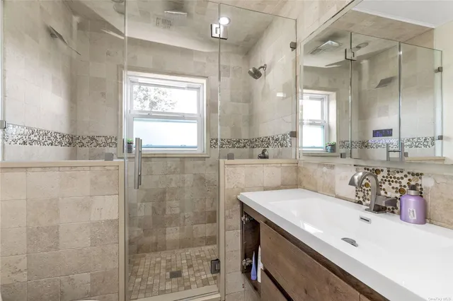 a bathroom with a sink a mirror and a shower
