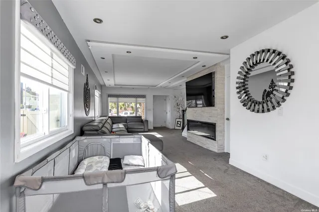 a large living room with a large window a fireplace and a large window