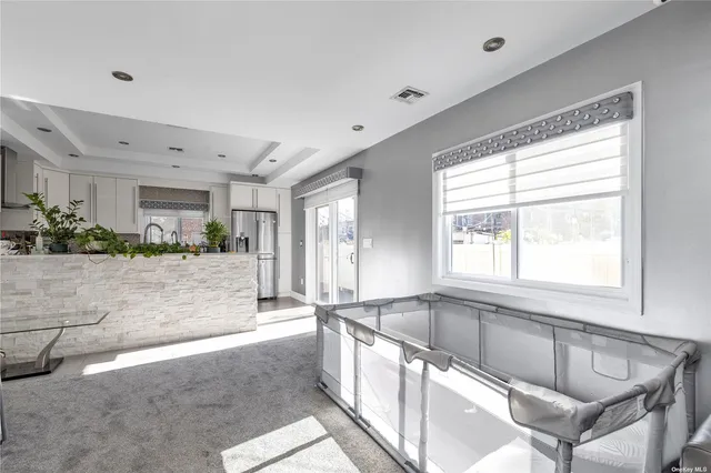 a large white kitchen with granite countertop a large counter top and a stove