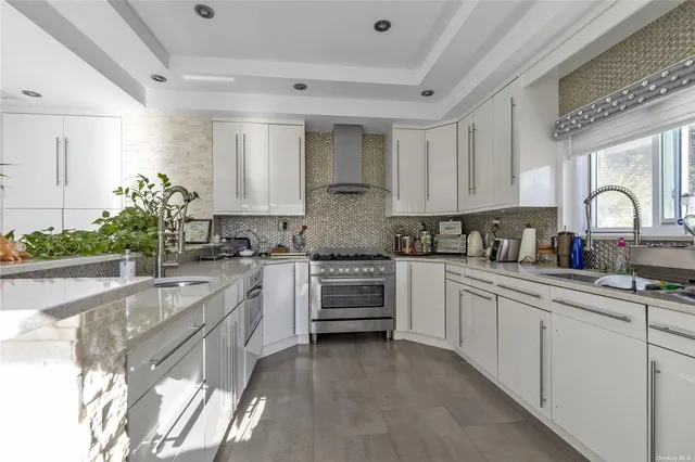 a kitchen with granite countertop white cabinets and white stainless steel appliances