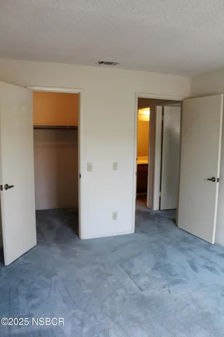 an empty room with closet and a bathroom