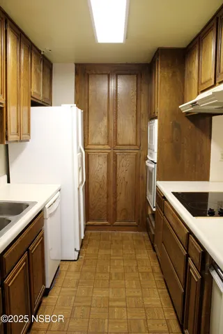 a kitchen with a refrigerator sink stove and cabinets