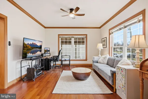 a living room with furniture a flat screen tv and a large window