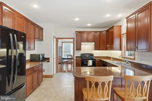 a large kitchen with stainless steel appliances granite countertop a sink and a refrigerator