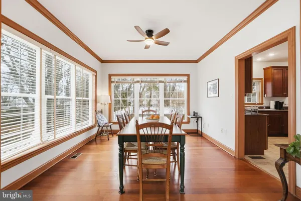 a view of a dining room with furniture a chandelier and wooden floor