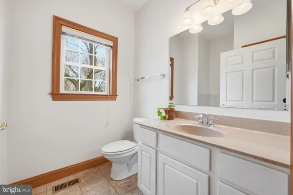 a bathroom with a toilet a sink and mirror