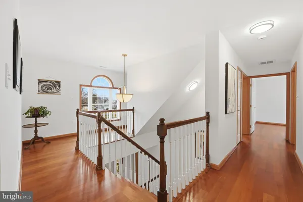 a view of a hallway with wooden floor and staircase