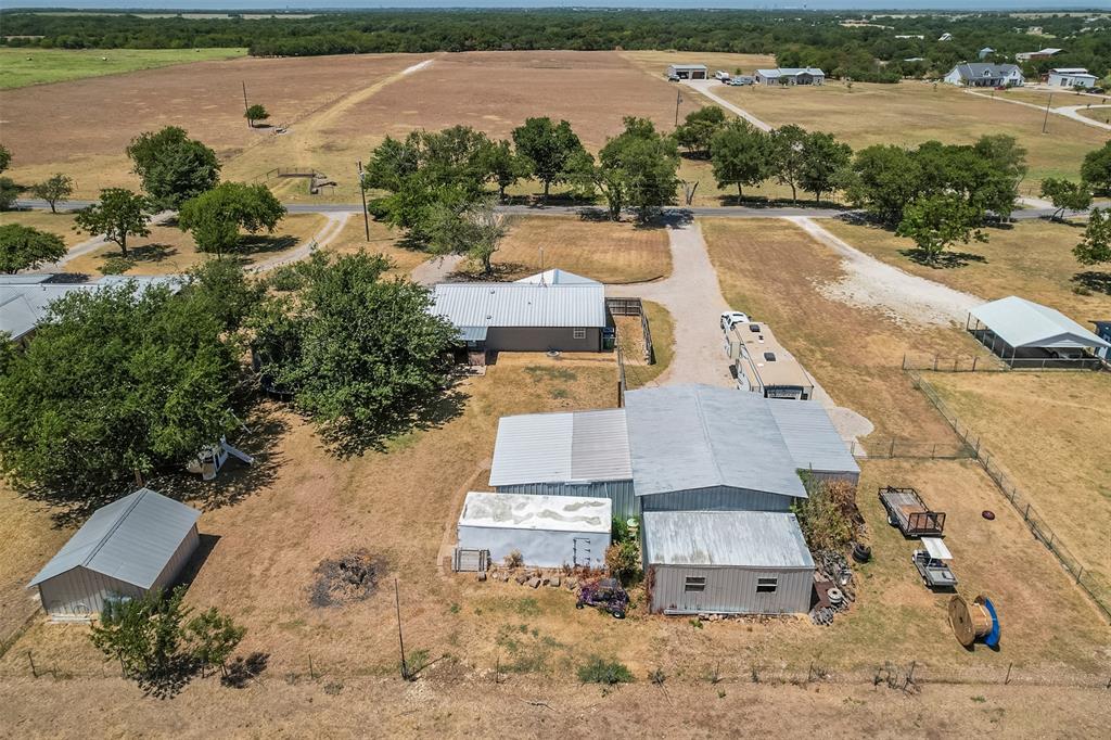 472 Cox Road Waxahachie, TX 75167 - Photo 30 of 31 Expansive rural property featuring multiple outbuildings, mature trees, and gravel driveways