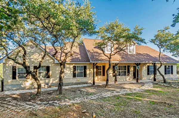 a front view of a house with a tree