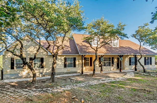 a front view of a house with a tree