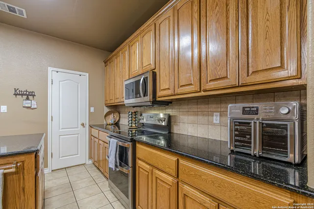 a kitchen with stainless steel appliances granite countertop a refrigerator a oven and a sink