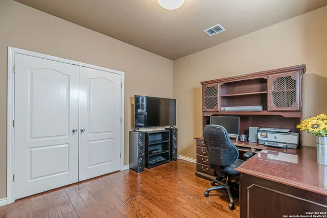 a view of a workspace with furniture and wooden floor