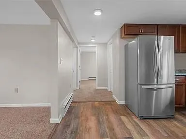 a view of a refrigerator in kitchen and wooden floor