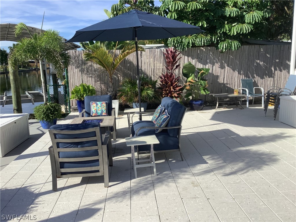 2642 York Road St. James City, FL 33956 - Photo 13 of 14 a view of a chairs and table under an umbrella in patio