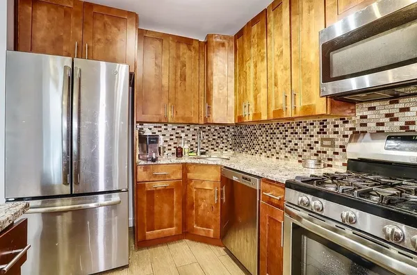 a kitchen with granite countertop a stainless steel stove and refrigerator