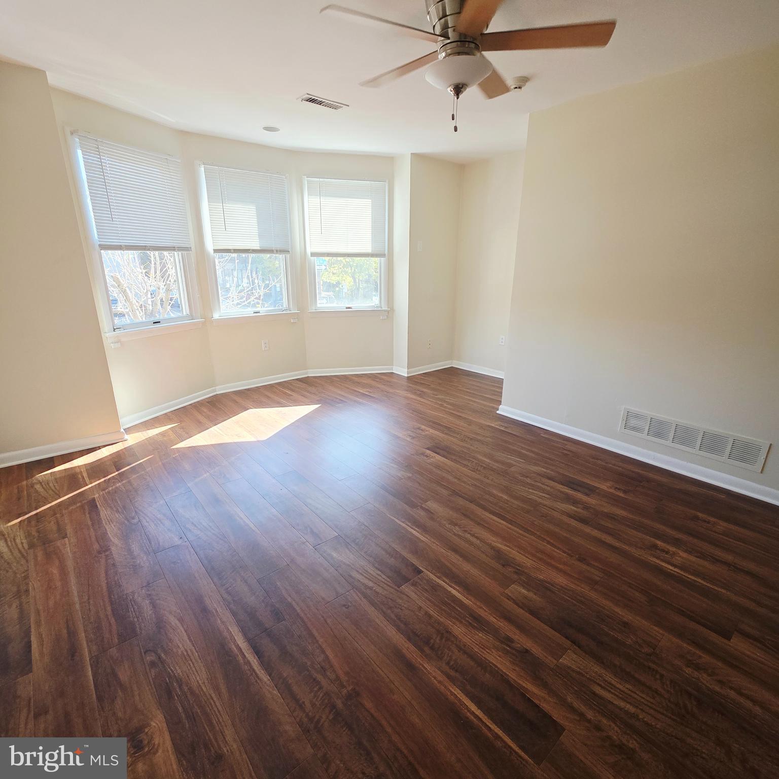 532 South 15th Street, Unit 2 Philadelphia, PA 19146 - Photo 4 of 11 an empty room with wooden floor fan and windows