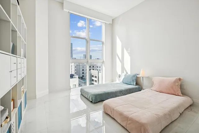 a bedroom with two beds and a large window