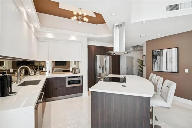 a kitchen with kitchen island a sink appliances and cabinets