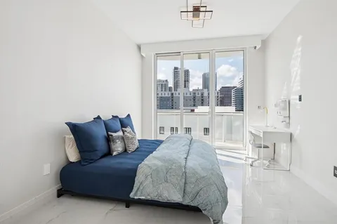 a bedroom with a bed and a large window