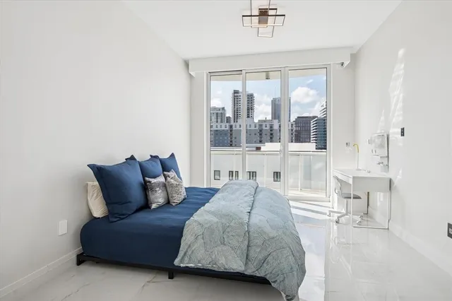 a bedroom with a bed and a large window