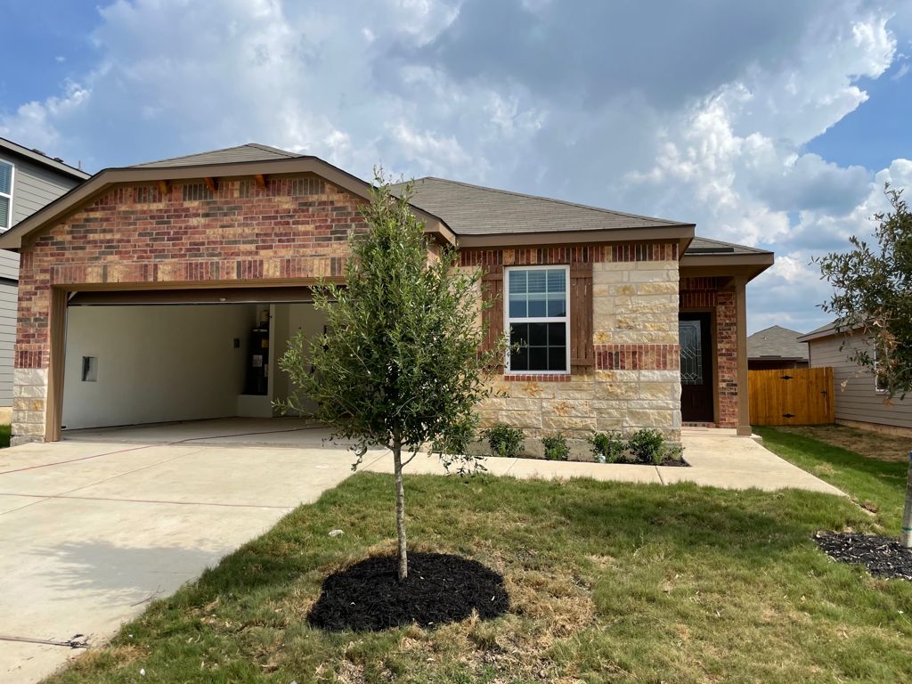 109 Declaration Lane Liberty Hill, TX 78642 - Photo 1 of 24 View of front of house featuring a garage, a front lawn, driveway, and brick siding