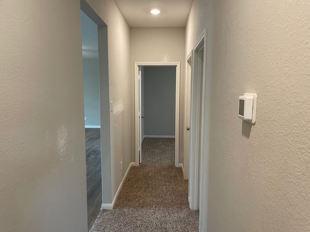 109 Declaration Lane Liberty Hill, TX 78642 - Photo 17 of 24 Hallway featuring a textured wall and dark colored carpet