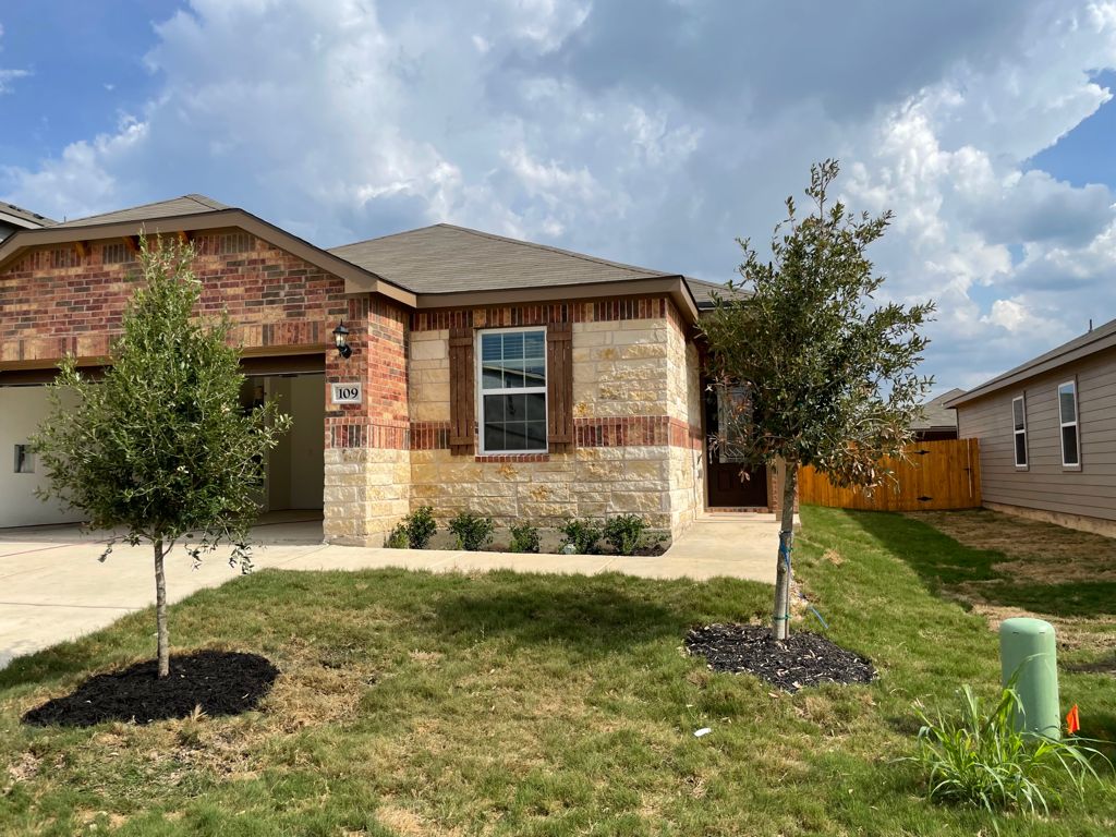 109 Declaration Lane Liberty Hill, TX 78642 - Photo 2 of 24 View of front of house featuring a garage, driveway, brick siding, and stone siding
