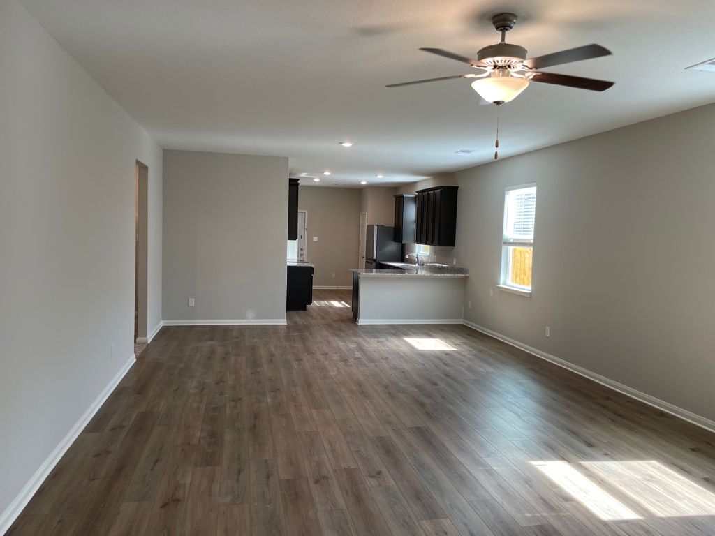 109 Declaration Lane Liberty Hill, TX 78642 - Photo 6 of 24 Unfurnished living room featuring ceiling fan, dark wood-style flooring, and recessed lighting
