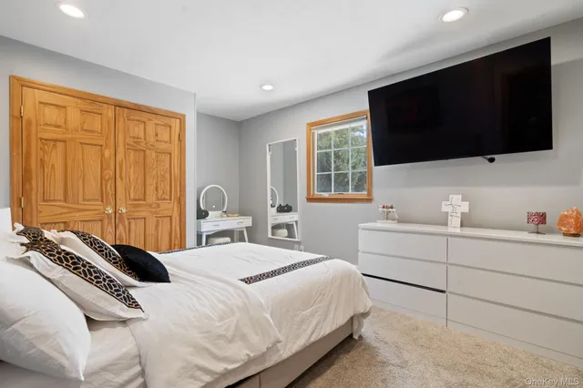 a bedroom with a bed tv and window